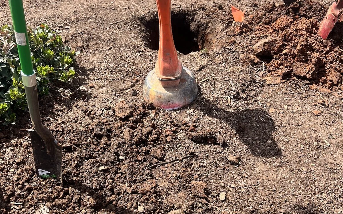 Potholing pit exposing a located utility line after a Texas 811 call