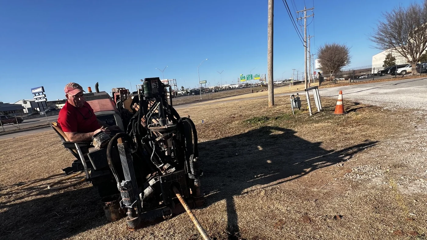 Boring crew and rig setting the bore path on an active commercial construction site